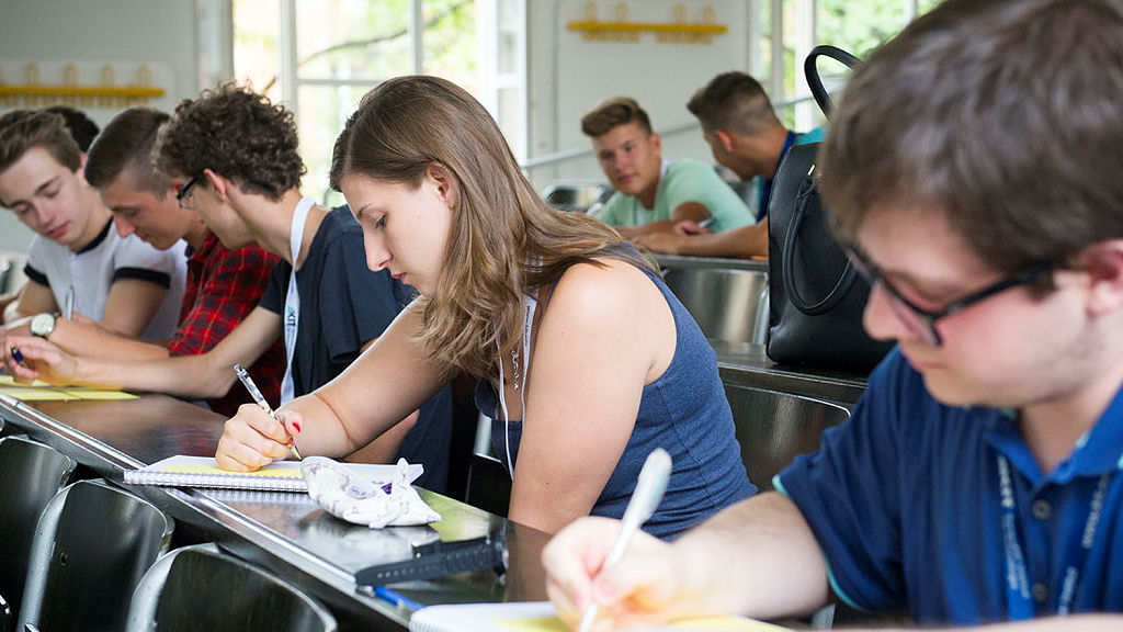 Studierende im Hörsaal, die sich Notizen machen